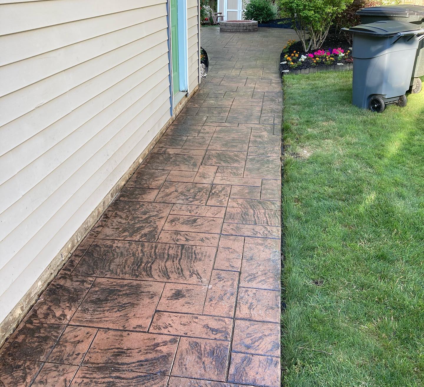 Xpress Construction & Services shows a neat walkway by a beige house with tidy landscaping and a clean, welcoming look.