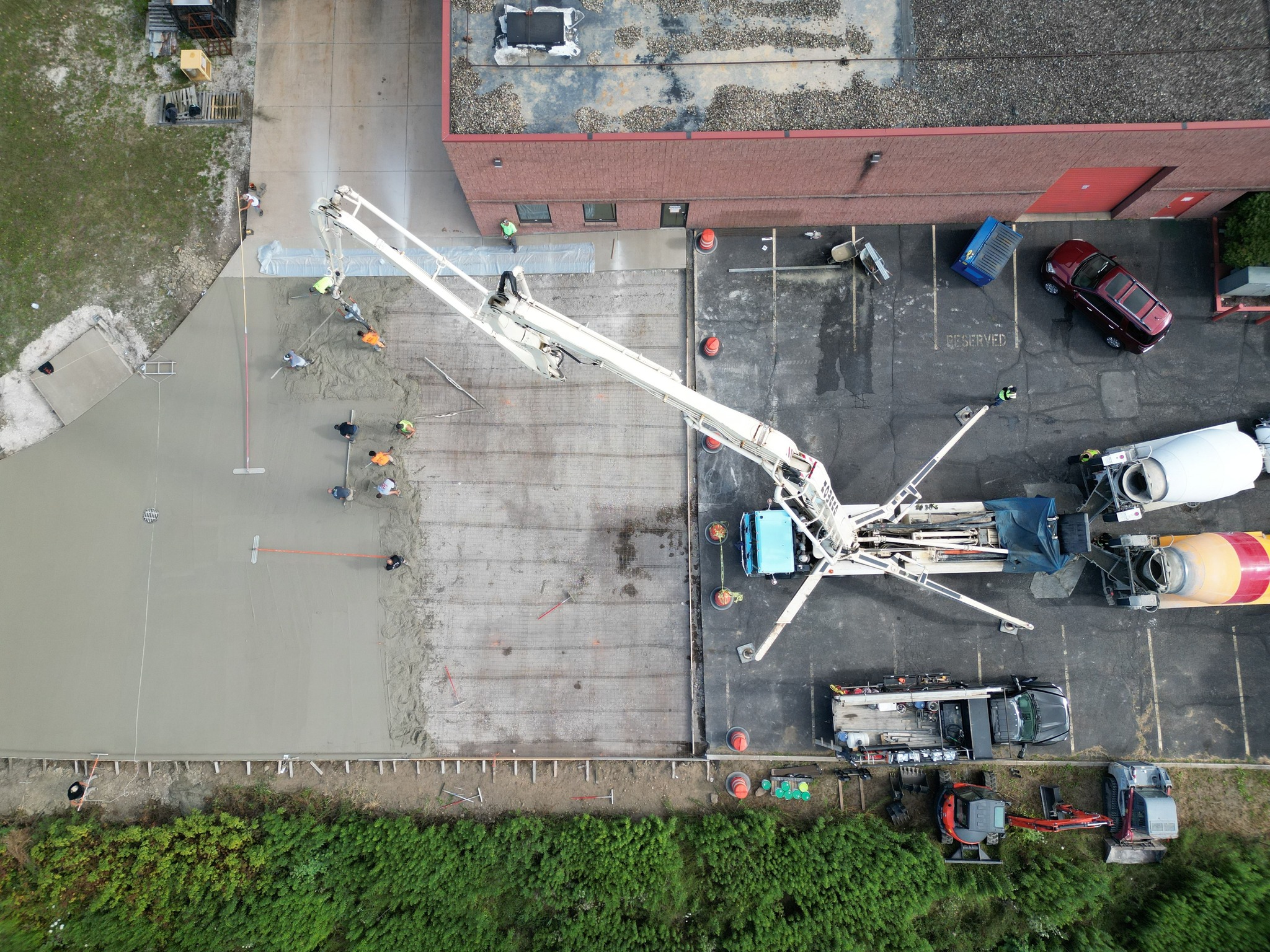 Xpress Construction & Services crews work together on a concrete project at a building site, showing teamwork and progress.