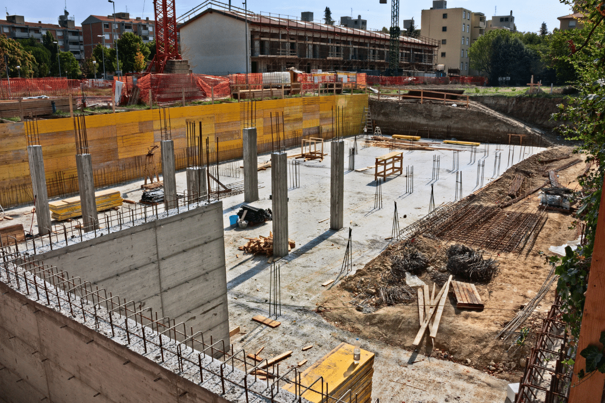 Xpress Construction & Services is hard at work building strong new structures in a busy area with nearby homes and trees.