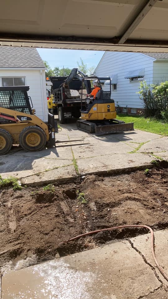 Xpress Construction & Services workers and machines improve a home's driveway and yard for a better-looking property.