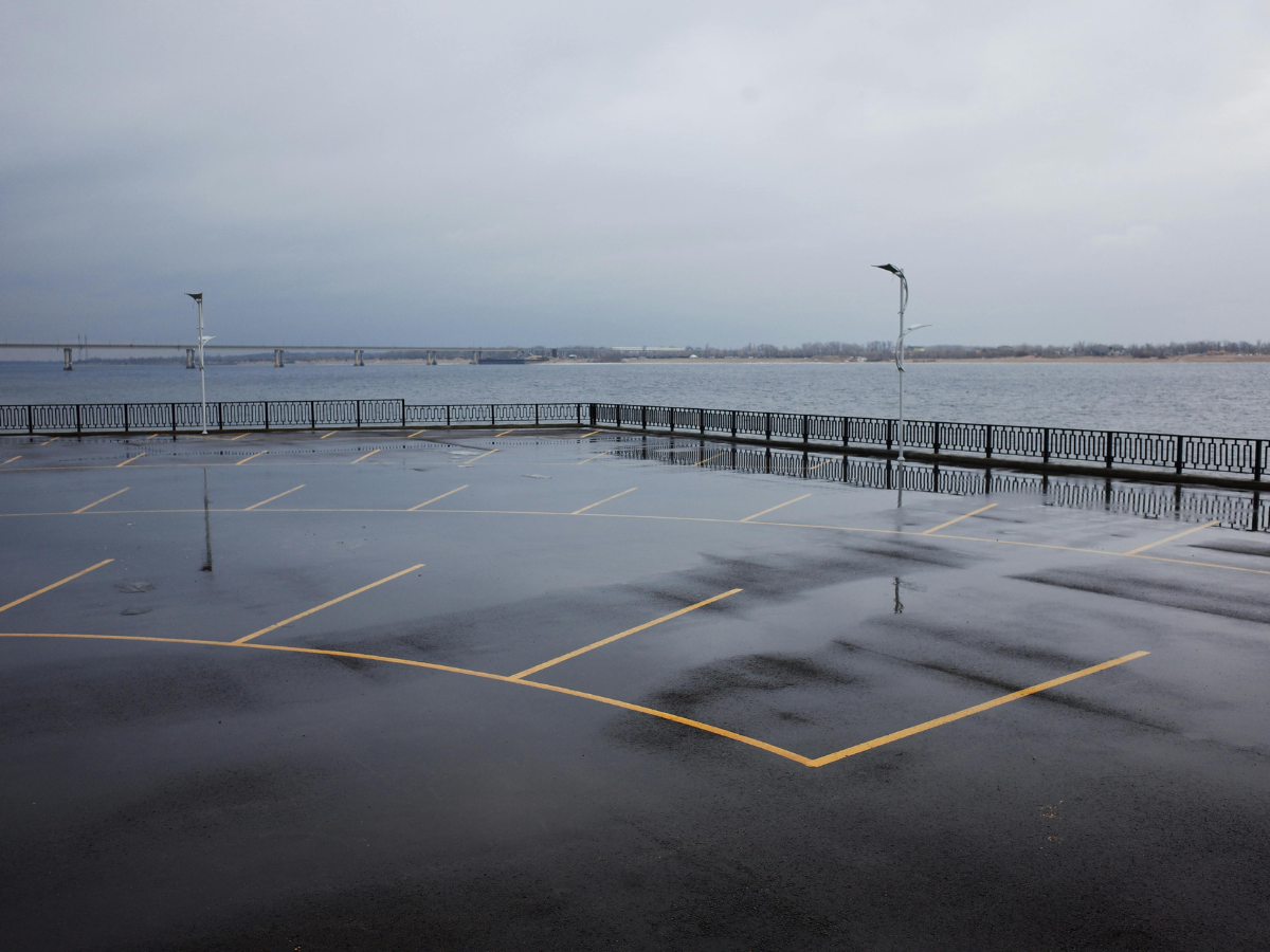 Xpress Construction & Services shows a clean, newly paved parking lot by the river, demonstrating quality concrete work.